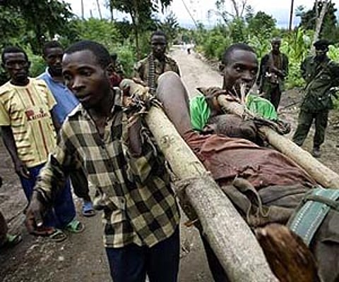 Rebel soldiers loyal to Gen Laurent Nkunda carry a soldier wounded in the village of Kiwanja in eastern DR Congo. AP