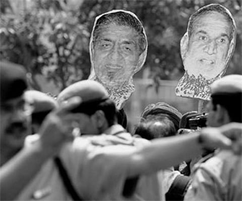 The police gesture as Sikh protestors carry placards of Jagdish Tytler and Sajjan Kumar during a recent protest outside Delhi’s Karkardooma courts