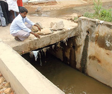 Death trap: A local points to the nala at Venkateshanagar into which Ramesh Kumar had stepped during the heavy rain in Hyderabad on Monday night.