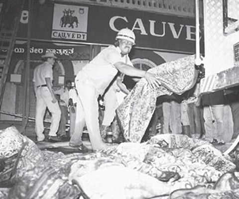 Firemen at the spot of the fire accident in Cauvery Emporium on M G Road on Tuesday.