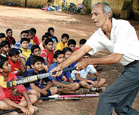 Coach Sreedhar Shenoy shares a few hockey tips with students at St John De Britto School, Fort Kochi.