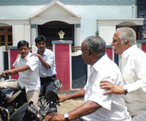 Congress candidate for Chikkodi constituency Prakash Hukkeri, rides pillion on a motorcycle during campaigning.