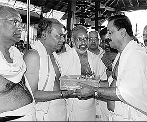 Guruvayur Devaswom chairman Thottathil Raveendran handing over at the Sree Krishna Temple in Guruvayur on Thursday the 400 kg of gold ornaments of the