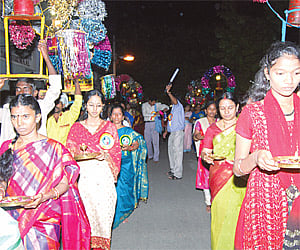 Women walking with lamps at the Hanumath Jayanthi celebrations at Nanganallur.