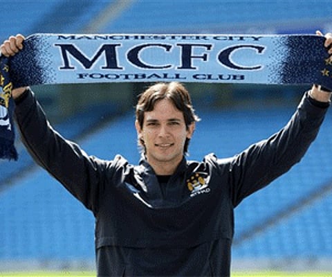 Manchester City's new signing, Paraguayan soccer player, Roque Santa Cruz holds up a team scarf during a photo call. (Photo: AP)