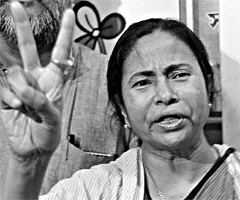 Mamata Banerjee (C) gives a victory sign as she meets the media in Kolkata.