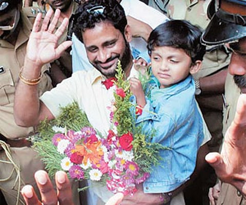 Academy Award winner Resul Pookutty, with his son Rayan in his arms, waving to the crowd on his arrival at the Thiruvananthapuram International Airpor