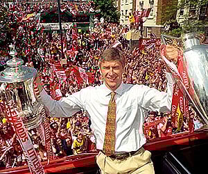 Wenger with the FA and League Cups as the team take a victory tour from the Highbury ground to Islington Town Hall. (AP file photo - May 17, 1998)