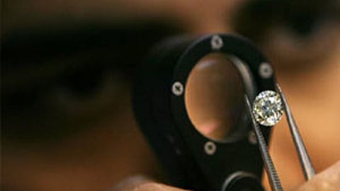 A diamond businessmen desmonstrates a process at a diamond cutting and polishing factory in Surat in Gujarat.