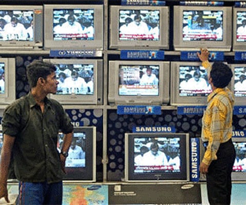 An salesman tunes televisions at an electronic consumer product shop in Kolkata. (Photo: Reuters)