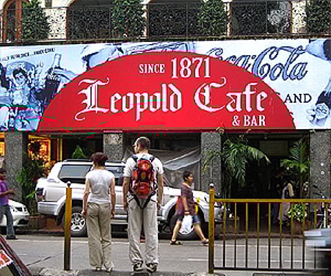 A couple of tourists in front of the Leopold Cafe in Mumbai. (Image reproduced as per the Wikimedia Commons license)