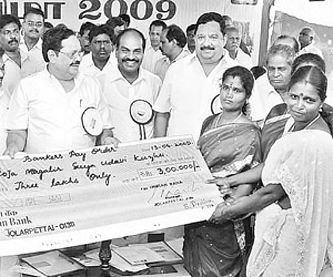 PWD Minister Duraimurugan giving away a cheque for Rs 3 lakh to a beneficiary of the Roja Magalir Suya Udavi Kuzhu during the Yelagiri Summer Festival