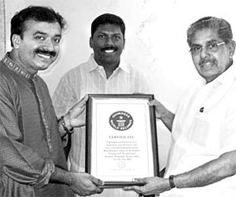 Union Minister for Overseas Indian Affairs Vayalar Ravi handing over the Guinness World Record certificate to mridangam maestro Kuzhalmannam Ramakrish