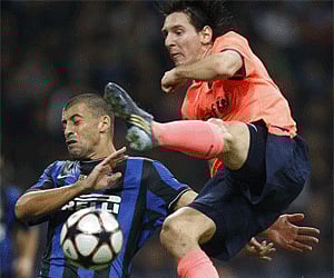 Barcelona forward Lionel Messi, of Argentina, right, goes airborne for the ball with Inter Milan Argentine defender Walter Samuel. (Photo: AP)