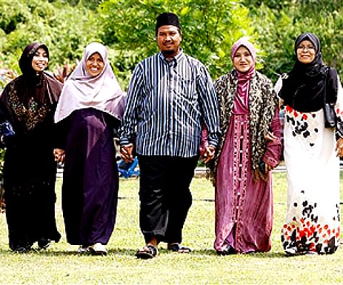 Mohammad Inaamulillah Bin Ashaari, centre, is seen with his four wives, near Kuala Lumpur. (Photo: AP)