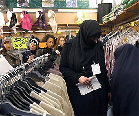 FILE - This April 4, 2010 file photo shows women in Islamic face-covering veils looking at clothes inside an exhibition hall in Le Bourget, Paris. AP