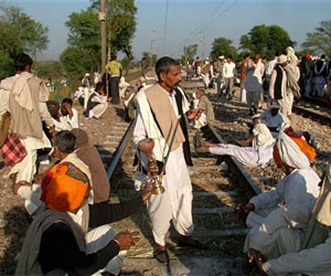 The members of the Gujjar tribe sit on railway tracks to block trains at Peelipura in Bharatpur district of Rajasthan. AP