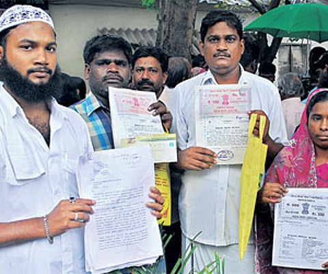 The victims showing the forged land documents, in the city on Friday/A Raja Chidambaram.