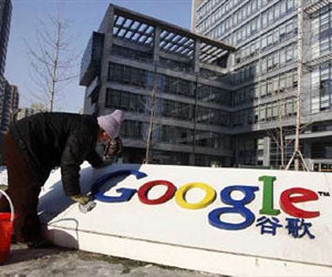 A woman cleans the logo of Google China outside the company headquarters in Beijing January 14, 2010. (Reuters)