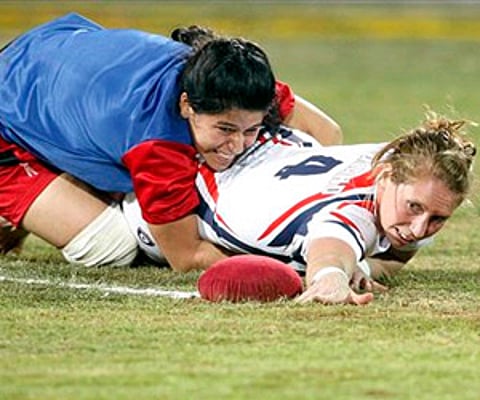 A Turkmenistan player, top, tackles a British player during their women's match in the Kabaddi World Cup in Jalandhar. (AP)