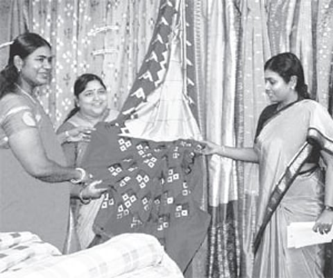 Minister of state for textiles Panabaka Lakshmi along with mayor Banda Karthika Reddy looking at a saree during an exhibition at the inauguration of t