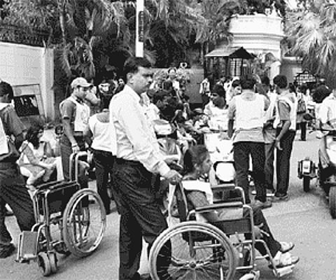 Children, parents and volunteers wait for more than an hour outside Raj Bhavan on Sunday for the Governor to flag off a walkathon.