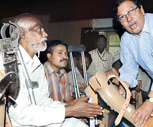 Former Lokayuta Justice Santosh Hegde distributing Jaipur Foot to people on Sunday at Victoria Hospital | Sudhakar Jain