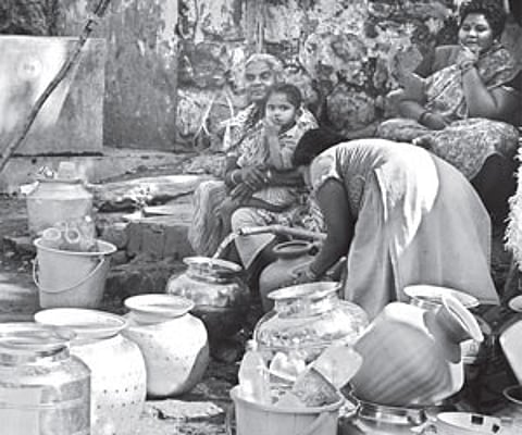 Women queue up at the public tap at Relliveedhi in Visakhapatnam on Monday. | Express Photo