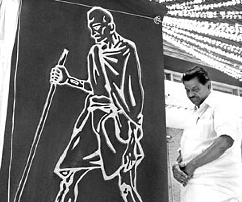 Thiruvanchoor Radhakrishnan beside the lino cut image of Gandhiji unveiled at Gandhi Bhavan on Tuesday.