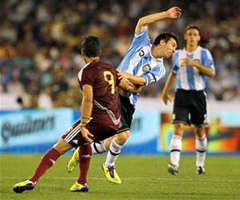 Argentina's Lionel Messi, second left, is blocked by Venezuela's Frank Feltscher during a friendly soccer match in Kolkata, Friday. (AP)