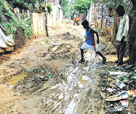 WHAT A MESS! A boy tries to cross a dirty road in Gandhi Nagar, Pattabiram. D Sampathkumar