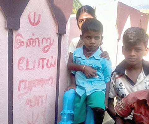 FEAR PSYCHOSIS: Children sitting by the side of a wall of a house on which it is written ‘Indru Poi Nalai Va’, to ward off the evil spirit. EPS