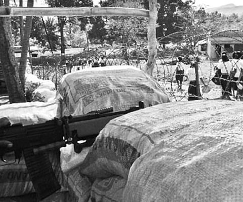 Schoolgirls walk past a Border Security Force camp at Podapadar village, Narayanpatna