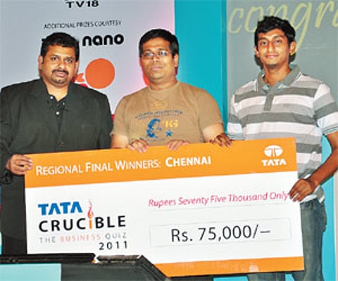 Quizmaster Giri Balasubramaniam hands over the cheque for Rs 75,000 to the winners Balaji and Arun Laxman in the Tata Crucible Business Quiz 2011.