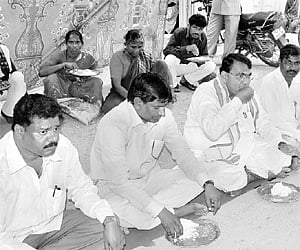 TRS candidate Pocharam Srinivasa Reddy (centre) having community lunch in Banswada on Saturday. | A Radhakrishna