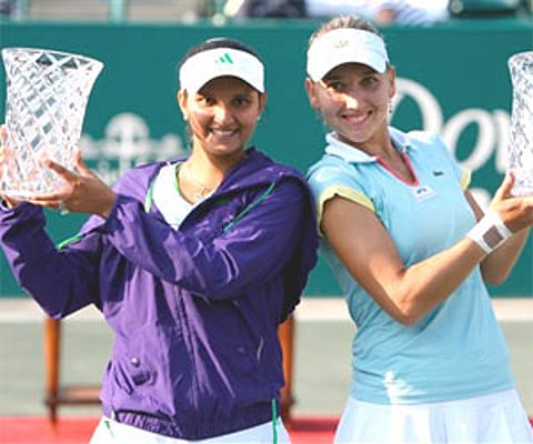 Sania Mirza of India and Elena Vesnina, of Russia hold their trophies after winning the Family Circle Cup tennis tournament in Charleston, Sunday. AP