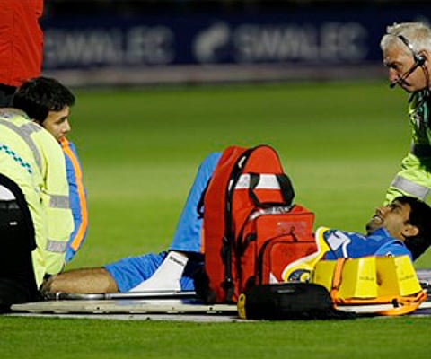 Munaf Patel is treated after slipping on the grass during their ODI match against England, at Sophia Gardens ground in Cardiff on Friday. (AP)