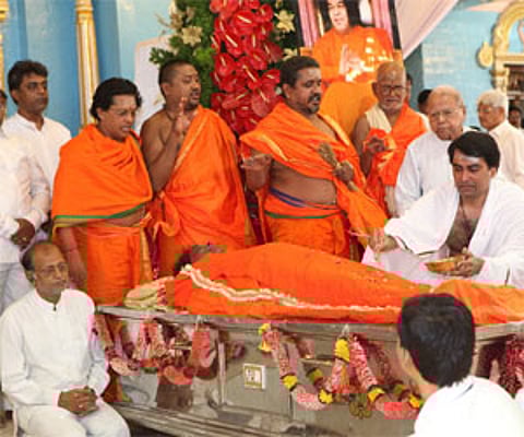 Sathya Sai trust central board member Ratnakar Rao performs rituals during the funeral of Sri Sai Baba. EPS