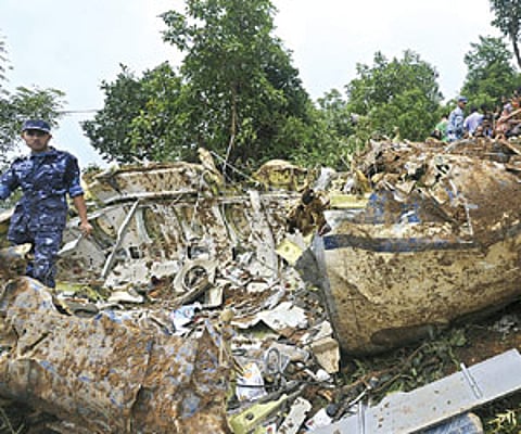 Onlookers gather as rescuers are seen near the wreckage of the Buddha Air plane that crashed on Sunday in Kotdanda.