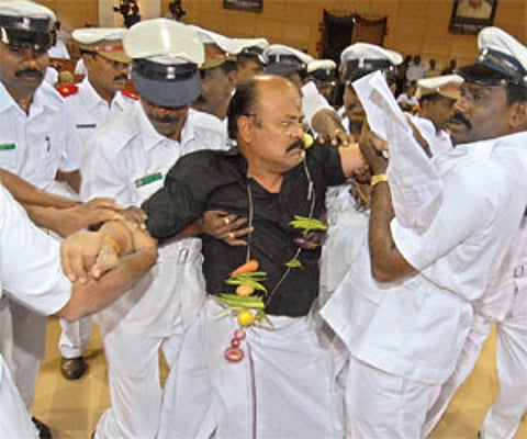 fighting it out: An AIADMK MLA gives a hard time to marshals who were forced to evict him from the Assembly on Friday.