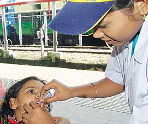 IMMUNISATION DRIVE: A kid being administered polio drop by a health worker at Bhubaneswar Railway Station on Sunday I Express/Shamim.