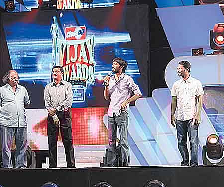 Dhanush receives the trophy on behalf of Rajinikanth, who won the award for Most Favourite Hero.