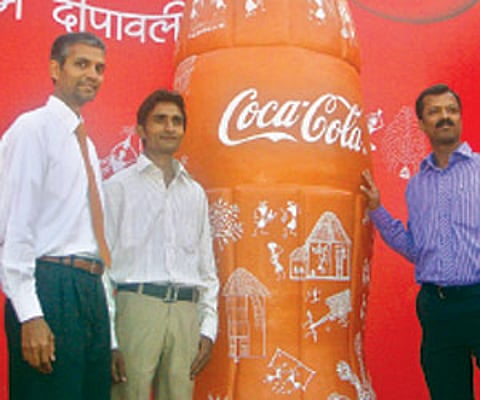 Om Prakash Galav (second from left) with the 10 feet tall terracotta coke bottle