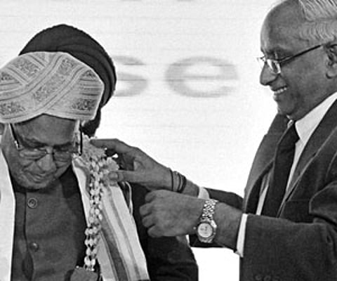 Ramnath Pradeep presenting a traditional headgear to Finance Minister Pranab Mukherjee in New Delhi on Saturday