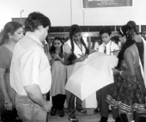Students signing on an umbrella to express solidarity with the vegetable farming initiative.