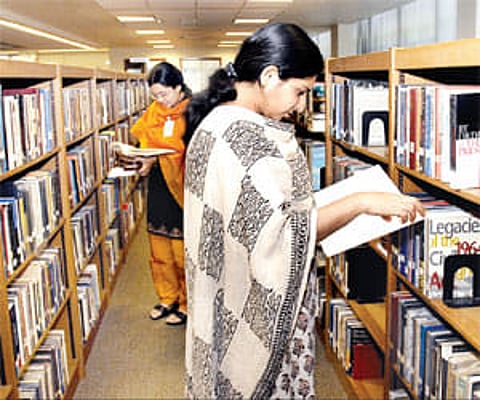 A file picture of people browsing through books in a library.