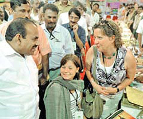 Tourism Minister Kodiyeri Balakrishnan exchanging pleasantries with a foreign delegate at the Kerala Travel Mart in Kochi (Pic: ENS).