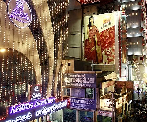 Bright lights decorated in shopping area at T Nagar spreads festive cheer to people for Diwali festival in Chennai. (EPS)A woman carries idols of gods for sale ahead of Diwali festival in Allahabad. (AP)People make traditional sweets for sale ahead of Diw