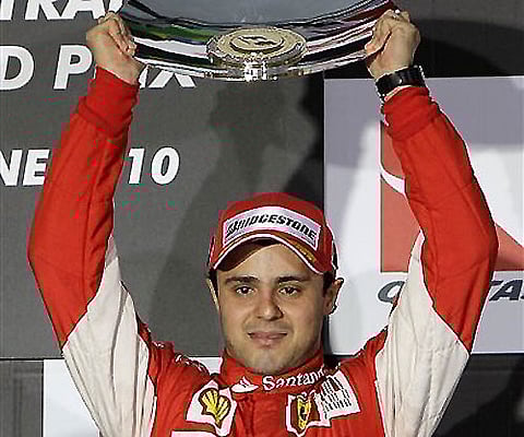 Ferrari Formula One driver Felipe Massa of Brazil holds his trophy aloft after finishing in third place at the Australian Formula One Grand Prix in Melbourne on Sunday. AP