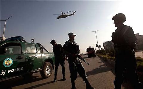 Yemen security officials stand guard as a helicopter hovers at the site of a gunfire attack on a road linking Taiz to the rest of the country